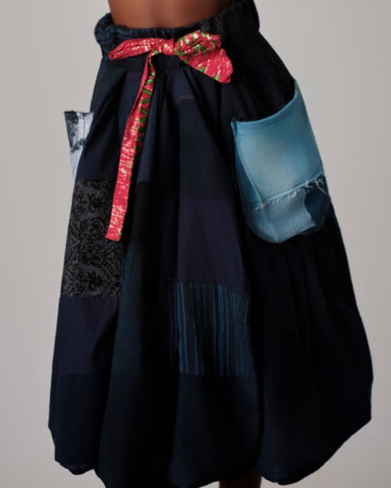 Black patchwork skirt with colorful accents on a neutral background