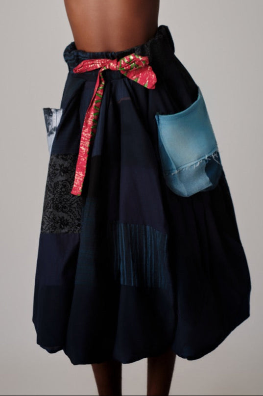 Black patchwork skirt with colorful accents on a neutral background