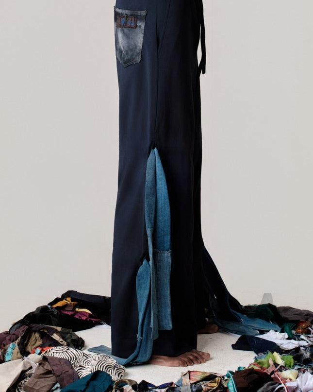 Person wearing dark blue pants standing on a white platform with colorful fabric around them.